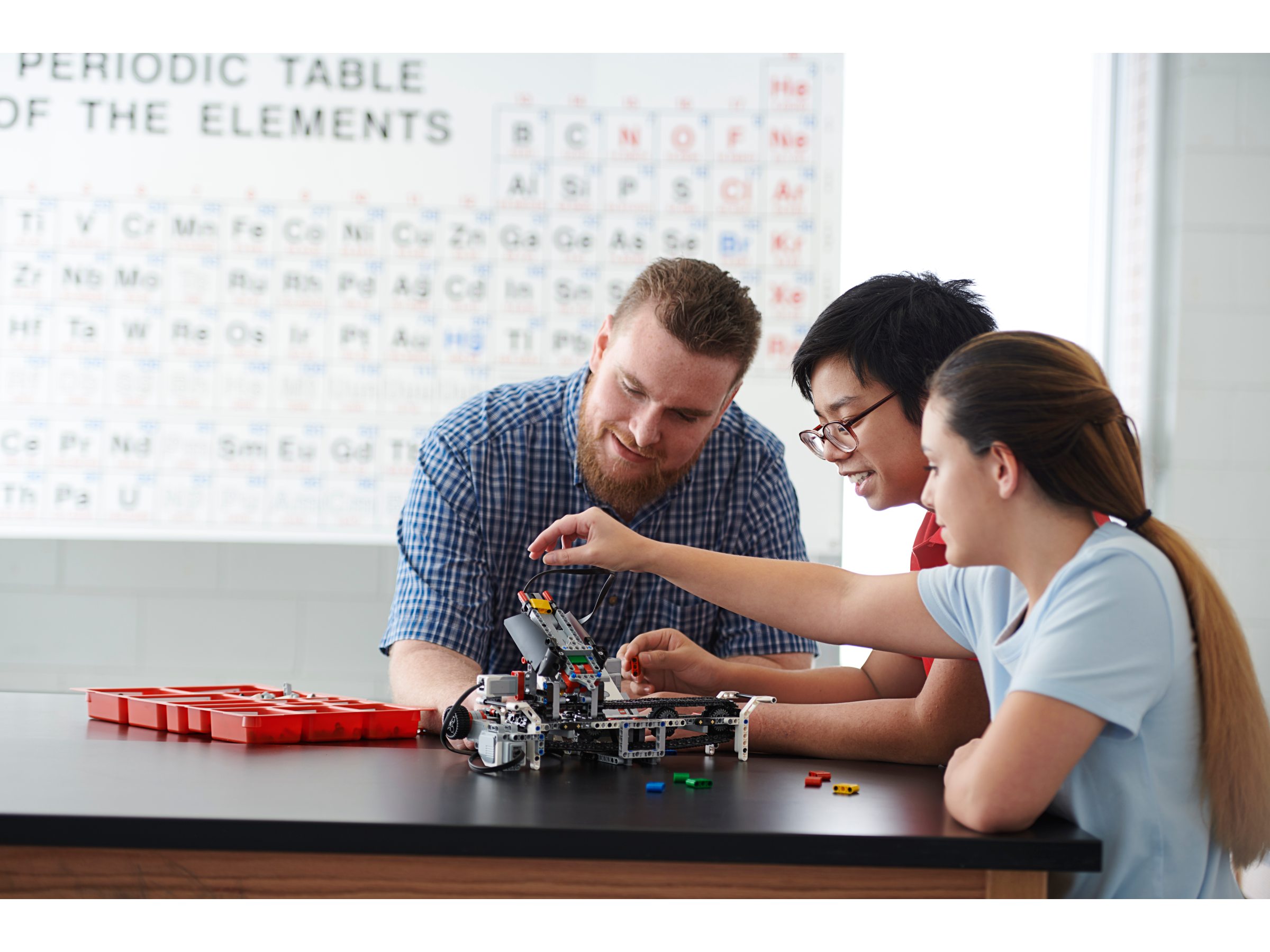High school teacher instructs two students on how to use LEGO MINDSTORMS Education EV3